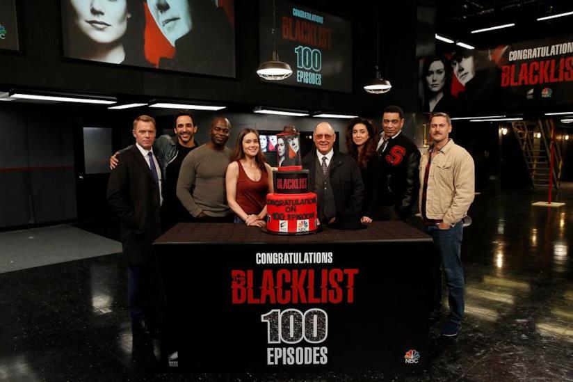 L'intera squadra di The Blacklist ha festeggiato i primi 100 episodi della serie I protagonisti della serie TV dietro la torta per i primi 100 episodi