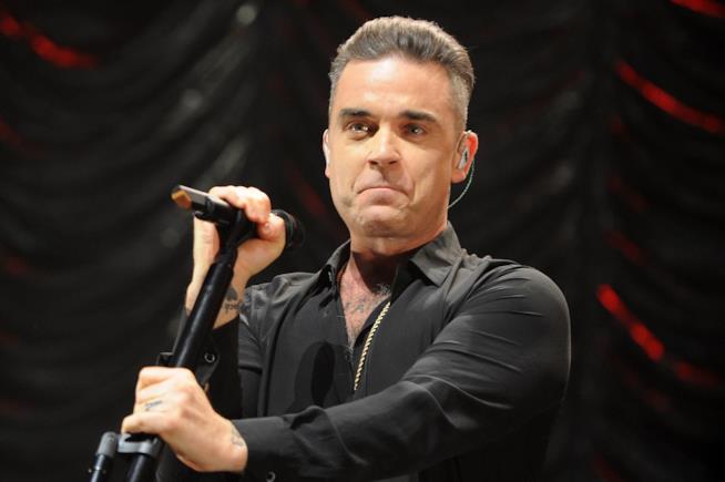 Robbie Williams si disinfetta le mani dopo aver salutato i fan in concerto Primo piano di Robbie Williams