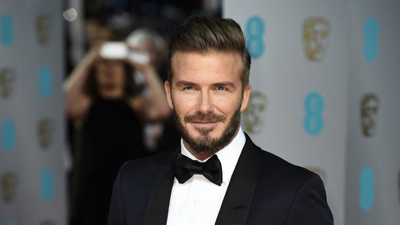 David Beckham cuce i vestitini delle bambole della figlia Primo piano di David Beckham