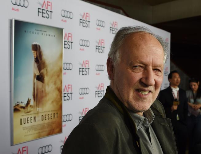 Werner Herzog è in uscita con la pellicola Queen of the Desert: un film biografico. Locandina del film The queen of the Desert alle spalle del regista Herzog