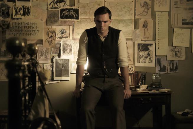 Un giovane J.R.R. Tolkien nella prima immagine del biopic Nicholas Hoult nei panni di Tolkien seduto su una scrivania, sullo sfondo di una parete con disegni