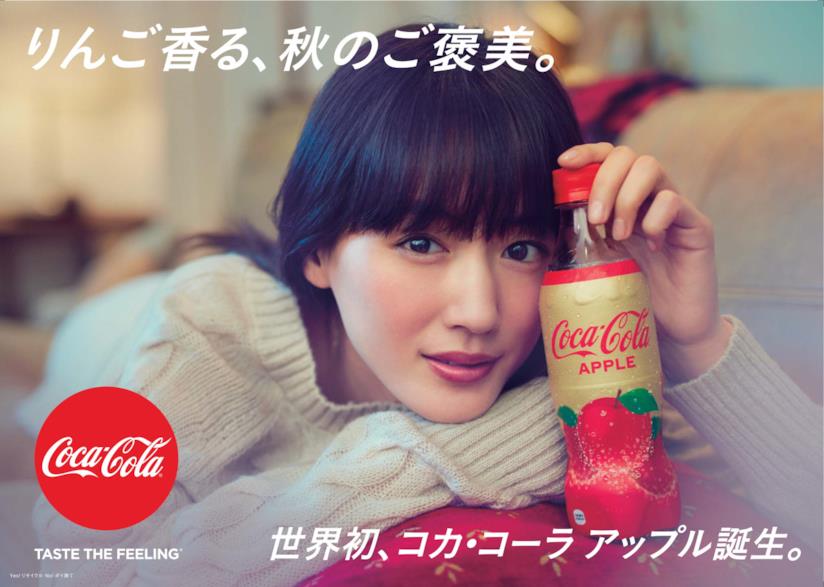 Nuovo gusto alla mela della Coca-Cola Una ragazza giapponese con la nuova Coca-Cola al gusto mela