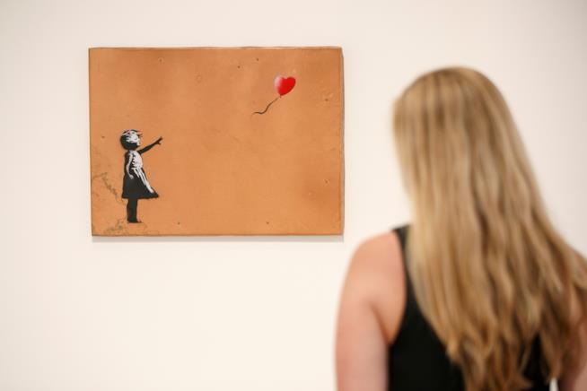 Banksy e il dipinto che si autodistrugge dopo un'asta da oltre 1 milione di euro Una foto in cui è ritratto il dipinto Balloon Girl di Banksy