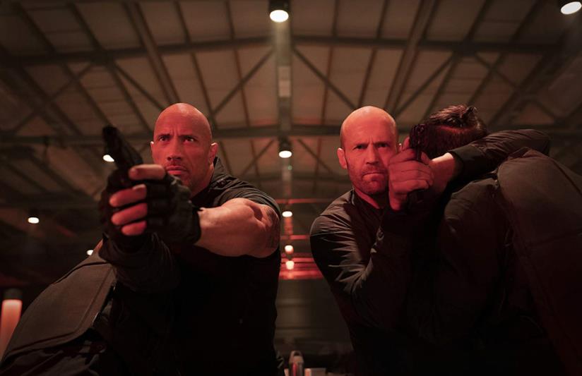 Fast & Furious - Hobbs & Shaw, nel film due cammei eccellenti Dwayne Johnson e Jason Statham pistole alla mano in una scena di Hobbs & Shaw