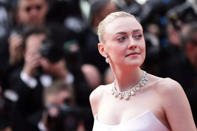 Dakota Fanning risponde alle critiche sul suo coinvolgimento nel film Sweetness In The Belly L'attrice Dakota Fanning in abito elegante bianco, fotografata sul red carpet
