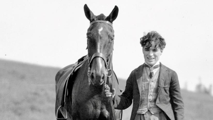 Carmen Chaplin alla regia di Charlie Chaplin, a Man of the World Una foto d'epoca di Charlie Chaplin sul set assieme a un cavallo